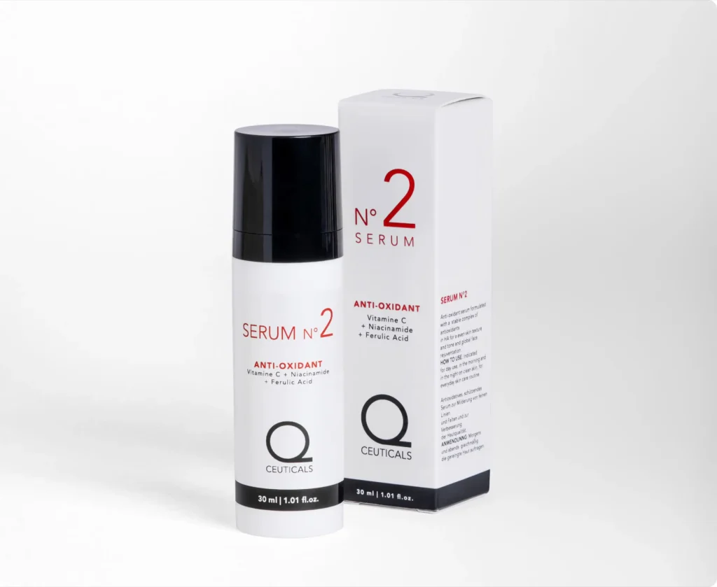 A bottle of Q Ceuticals No. 2 Serum is a sophisticated enhancement to any cosmetics collection, presented in stylish white and black packaging. This antioxidant serum boasts powerful ingredients such as Vitamin C, Niacinamide, and Ferulic Acid. The packaging box is predominantly white with eye-catching red and black lettering.